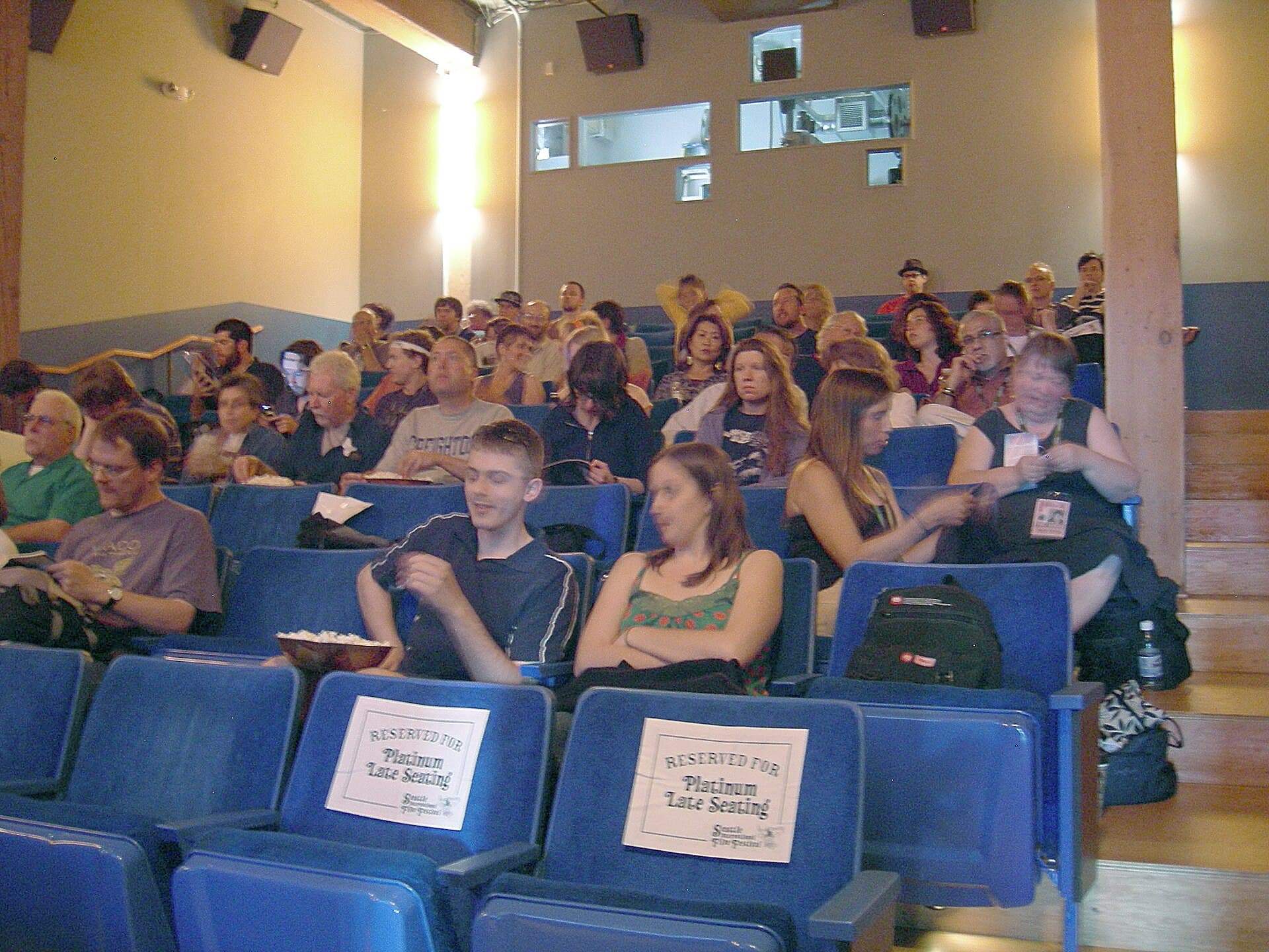 Plateia em sala de cinema durante a exibição de um filme