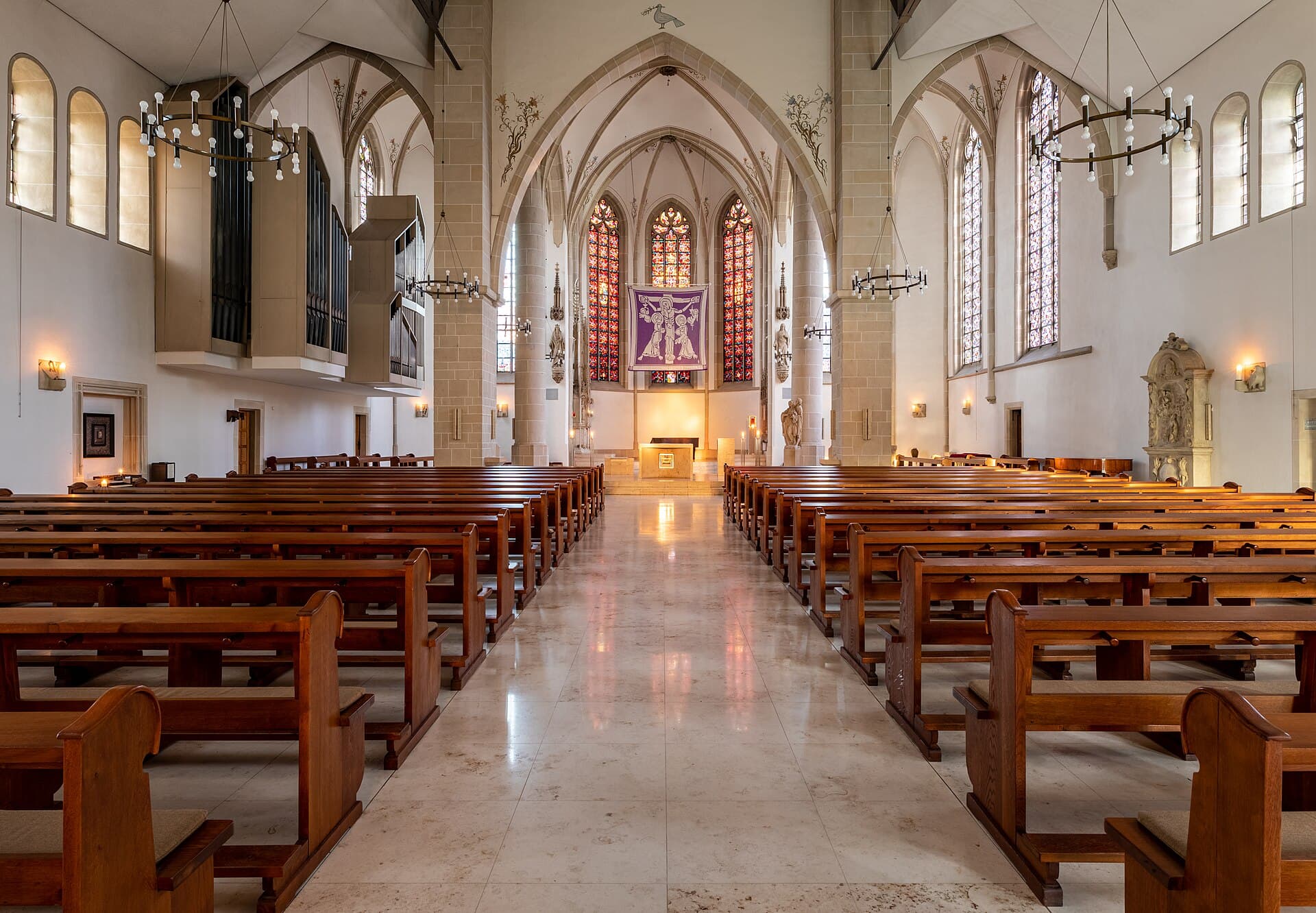 Interior silencioso de uma igreja, com bancos vazios e luz suave