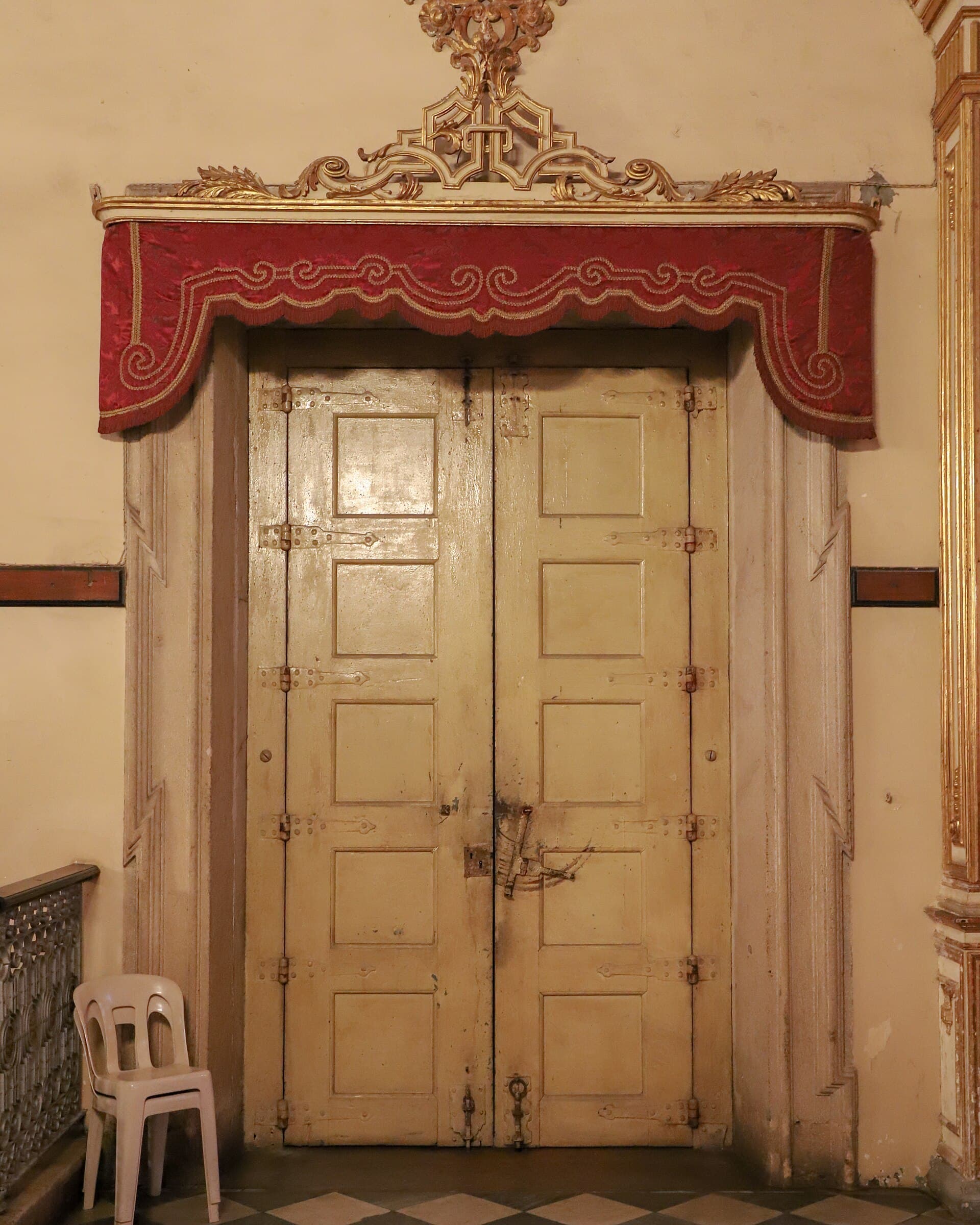 Porta de igreja histórica com talha dourada e ornamentos entalhados